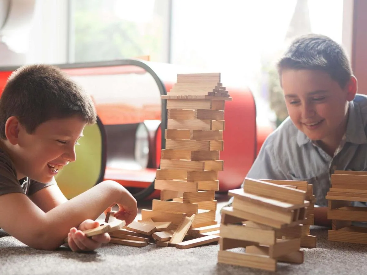 two young boys playing with a wooden chess set at Novotel Cardiff Centre in Cardiff